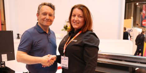 Rob Harrison of the Handsome Prints Company shakes hands on the deal with Sarah Fenna on the CMYUK stand at Sign & Digital UK